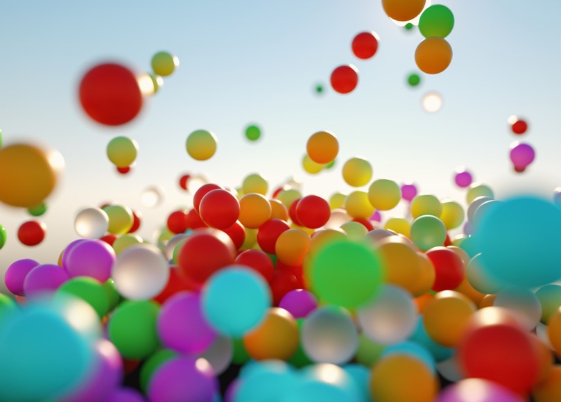 Colorful,Bouncing,Balls,Outdoors,Against,Blue,Sunny,Sky